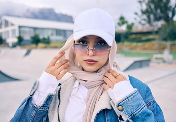 Image showing Portrait, fashion or sunglasses with an islam woman outdoor in a cap and scarf for contemporary style. Arab, face and hijab with a trendy young muslim female person posing outside in modern eyewear