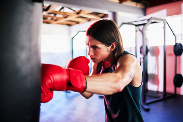 Image showing Punching bag, man and boxing in gym for exercise, workout or training for fight. Boxer, sports and serious fitness athlete punch for challenge, competition or exercising body for martial arts power.