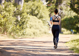 Image showing Woman, fitness and running in nature for exercise, cardio workout or training in the outdoors. Rear view of fit, active and sports female person, athlete or runner exercising for healthy wellness