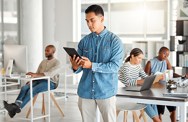 Image showing Serious, business tablet and man, designer or creative in office workplace. Touchscreen, technology and male professional typing on email app, graphic design research or reading website on internet.