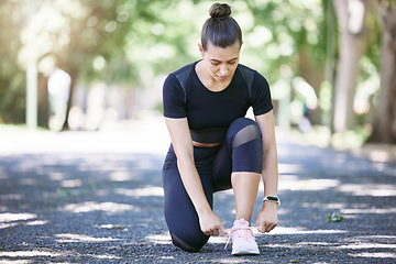 Image showing Fitness, woman tying her shoelaces and running outdoors at a nature park. Workout or exercise, training or health wellness and female person prepare to run outside for motivation with shoes.