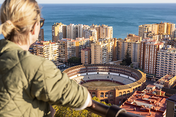 Image showing Bolnde female touris enjoying amazing panoramic aerial view of bull ring in Malaga, Spain