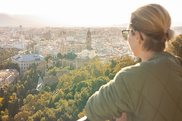 Image showing Bolnde female touris enjoying amazing panoramic aerial view of Malaga city historic center, Coste del Sol, Andalucia, Spain.