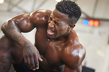 Image showing Exercise, muscle and pain with a black man bodybuilder breathing in the gym, exhausted after a workout. Fitness, injury and sweat with a intense, shirtless male athlete taking a break from training