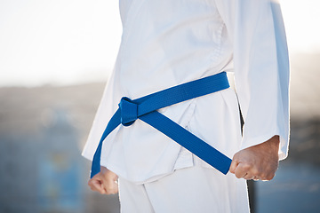 Image showing Karate, fitness and discipline with a sports man in gi, training in the city on a blurred background. Exercise, fighter or strong with a male athlete during a self defense workout for health closeup