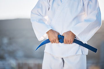 Image showing Karate, exercise and fighting with a sports man in gi, training in the city on a blurred background. Fitness, discipline or strong with a male athlete during a self defense workout for health closeup