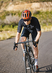 Image showing Exercise, bike and cycling with a sports man on a road through the mountain for cardio or endurance. Fitness, workout or training with a male cyclist riding his bicycle on an asphalt street in nature