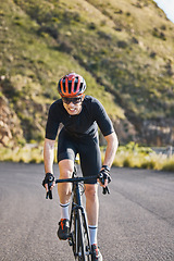 Image showing Fitness, bike and cycling with a sports man on a road through the mountain for cardio or endurance. Exercise, workout or training with a male cyclist riding his bicycle on an asphalt street in nature