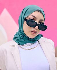 Image showing Young muslim woman, fashion and portrait by wall with trendy gen z aesthetic, beauty and art deco in city. Edgy islamic girl, student and clothes with sunglasses, freedom and travel in Dubai metro