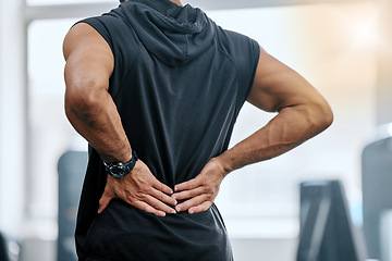 Image showing Gym, injury and man with hand on back pain for medical emergency from workout at sports studio. Exercise, health and wellness, bodybuilder with hands on muscle to massage ache or cramp while training