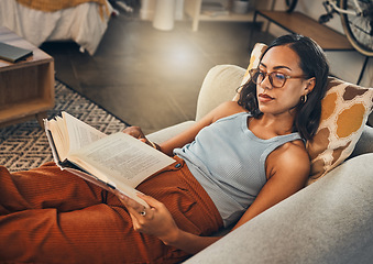 Image showing Woman relax on sofa, reading book at house and break on the weekend with literature, fantasy story and peace. Female person with hobby, leisure and chill at home, read for knowledge and information