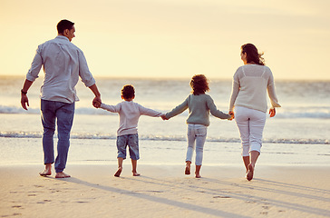 Image showing Walking, beach and back of family holding hands on holiday, summer vacation and weekend at sunset. Nature, travel and mother, father and children by ocean for bonding, adventure and quality time