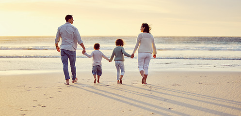 Image showing Sunset, walking on beach and family holding hands on holiday, summer vacation and weekend. Nature, travel and mother, father and children by ocean for bonding, adventure and quality time together
