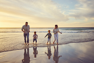 Image showing Beach, sunset and parents play with children on holiday, summer vacation and weekend together. Travel, family and happy mother, father and kids run in ocean for bonding, adventure and quality time