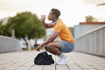 Image showing Drink, fitness and black man with water bottle in exercise, training or outdoor cardio workout. Athlete, drinking and healthy hydration or person relax after running in summer sport practice