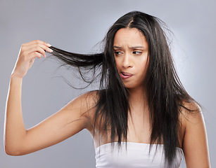 Image showing Hair care, damage and woman with worry in studio for split ends, haircare crisis and weak strand. Beauty mockup, hairdresser and face of upset female person with frizz problem on gray background