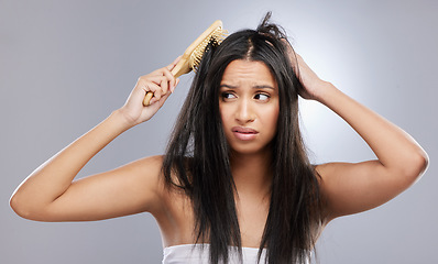 Image showing Hair, damage and woman with brush in studio with worry for knots, haircare crisis and weak texture. Beauty, hairdresser and face of female person with frizz, tangle and dry problem on gray background