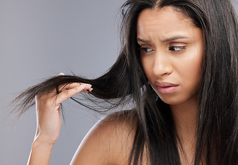 Image showing Hair, damage and face of woman worried in studio for split ends, haircare crisis and weak strand. Beauty, hairdresser and upset female person with frizz, dry and loss problem on gray background