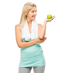 Image showing Apple, fitness and towel with a senior woman in studio isolated on a white background for health. Exercise, nutrition and diet with a happy mature female athlete holding fresh fruit for weightloss