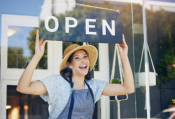 Image showing Portrait, plant nursery and open with a woman hanging a sign in the window of her shop for gardening. Small business, garden center and an excited young female florist opening her new flower store