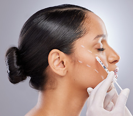 Image showing Face, filler and injection with woman in studio for plastic surgery, dermatology and beauty. Pattern, aesthetic and medical with model and syringe on grey background for collagen and cosmetics