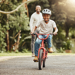 Image showing Boy with smile on bicycle, father and learn cycling with help, helmet for safety and family in park. Support, motivation and trust, black man and young kid outdoor, teaching and learning bike riding