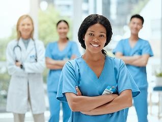 Image showing Portrait, medicine and a black woman nurse arms crossed, standing with her team in a hospital for healthcare. Leadership, teamwork and a female health professional in a medical clinic for treatment