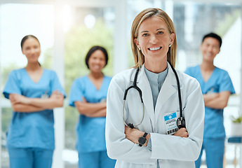 Image showing Portrait, team and a doctor woman arms crossed, standing in the hospital for healthcare or medicine. Leadership, medical or teamwork with a mature female health professional in a clinic for treatment