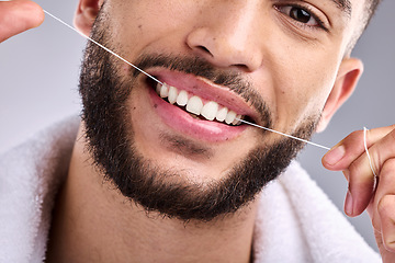 Image showing Face, man and flossing teeth for dental health in studio isolated on a white background. Portrait, floss and male model cleaning tooth for oral wellness, hygiene and healthy gums for fresh breath.