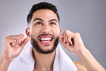 Image showing Face, man and floss teeth for dental health in studio isolated on a white background. Tooth, flossing and male model cleaning for oral wellness, fresh breath and healthy hygiene to stop gingivitis.