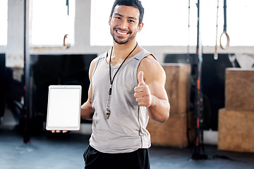 Image showing Portrait, thumbs up and man with tablet screen in gym for mockup after exercise. Face, like hand gesture and personal trainer with technology, happy and space for marketing, advertising and fitness.