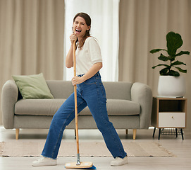 Image showing Woman, singing and broom to clean living room with funny dance, sweeping floor or performance in home. Girl, comic singer and cleaner with spring cleaning, music or working to stop dust, dirt and job