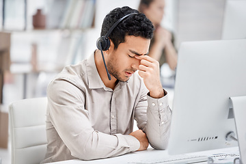 Image showing Mental health, man with headache and headset at his desk with computer in a modern workplace office. Telemarketing or call center, sad or burnout and male person tired or depressed at his workstation