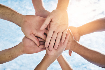 Image showing Hands in circle together, blue sky and community in collaboration for world support, trust and diversity. Teamwork, hand and summer sunshine, positive mindset and group of people in solidarity huddle