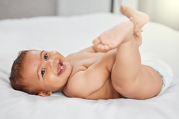 Image showing Baby, funny and child play with feet on bed in home having fun and enjoying time alone. Happy, newborn and playing with foot, toes and cute infant, kid or toddler with growth, development and relax