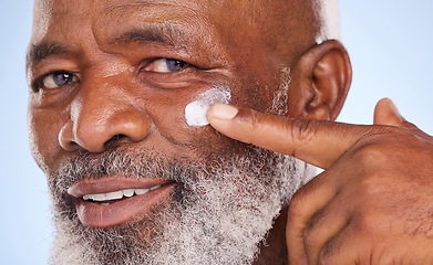 Image showing Skincare, cream and portrait of black man in studio for sunscreen, anti aging or beauty. Cosmetics, closeup or self care with lotion on face of model on blue background for facial, spa and product