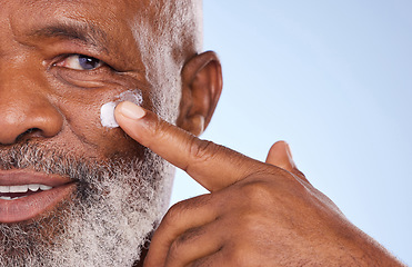 Image showing Skincare, cream and closeup of black man in studio for sunscreen anti aging or beauty. Cosmetics, mockup or self care with lotion on face of senior model on blue background for facial and spa product