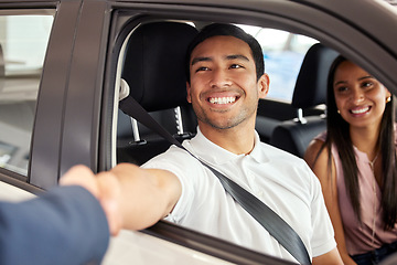 Image showing Car dealership, man and handshake from purchase and loan deal at motor showroom with salesman. Couple, happy and smile with shaking hands from agreement, payment and contract with a transport sale