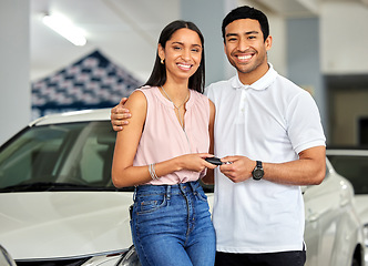 Image showing Couple at car dealership, choice and transport with key, people buy new vehicle with luxury and smile in portrait. Happy with decision, man and woman at automobile showroom with purchase and cars