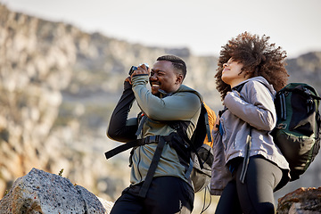 Image showing Hiking, camera and photographer with couple in mountains for journey, climbing and travel. Relax, trekking and adventure with black man and woman hiker in nature for exercise, picture and motivation