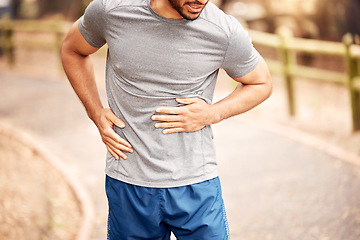 Image showing Stomach pain, fitness hands and man outdoor after running, workout and exercise. Sports, abdomen ache and male athlete in nature with injury, emergency hernia or problem, sick or training accident.