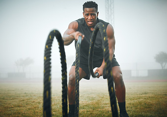 Image showing Fitness, battle rope and black man on field for power workout, body building and training muscle strength. Exercise, sports and African bodybuilder on grass with ropes, energy and outdoor performance