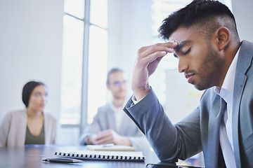 Image showing Mental health, businessman with a headache and at a business meeting with colleagues in a boardroom office at their workplace. Stress or depression, anxiety or tired and sad male person at a desk