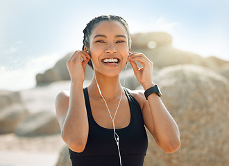 Image showing Happy woman with earphones, fitness at the beach and listening to music for motivation and workout outdoor. Exercise, health and smile, female athlete streaming online with radio and audio in nature