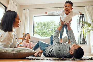 Image showing Family, father lifting son and playing in living room with fun and mother with daughter bonding at home together. Happy people with love, care and carefree, airplane and parents relax with kids