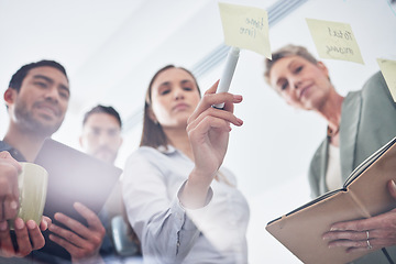 Image showing Teamwork, writing and business people on glass board for planning, brainstorming and schedule or workflow notes. Notebook, tablet and women, men or group with sticky note ideas, solution and window