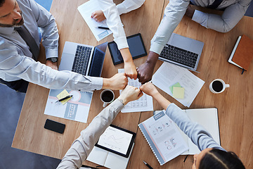 Image showing Fist bump, team building or top view of business people in collaboration for group mission in company. Motivation, fists or employees in meeting with goals, teamwork or support in office together