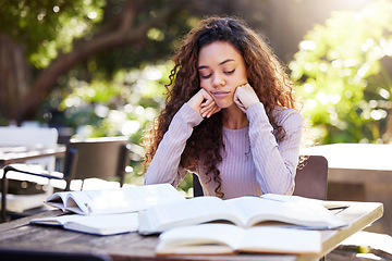 Image showing Tired, woman and study books in college, education and learning at outdoor, cafe or working on park table on campus. Girl, studying and university student to work, learn or research from reading