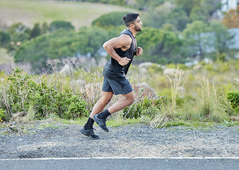 Image showing Man is running outdoor, fitness and cardio in nature with exercise and healthy, active body. Male runner on side of road, train for marathon with speed, energy and workout for health and sport