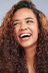 Image showing Laughing, curly hair and natural woman in studio with smile and face glow. Happy female person with beauty and healthy curls as benefits or results of shampoo or cosmetics on a grey background